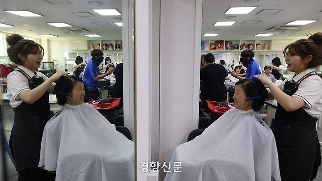 스승의날을 하루 앞둔 14일 충남 천안시 병천고등학교에서 미용 전공 학생들이 교사, 조리실무사 등 교육 공무직 직원들에게 마사지, 새치 염색 등을 해주는 행사를 하고 있다. 환경실무원 박원지씨가 커트를 받고 있다. 정효진 기자