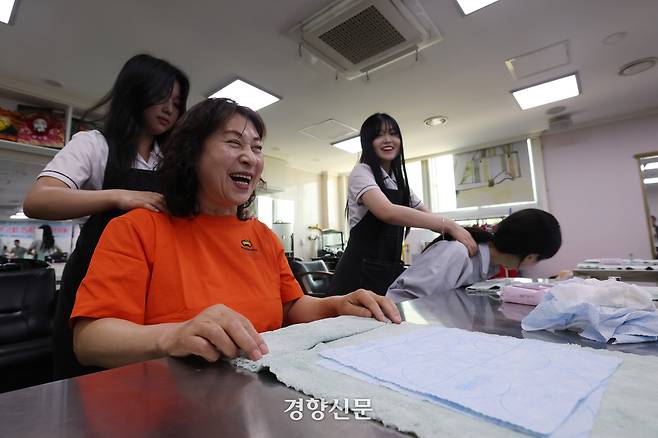 스승의날을 하루 앞둔 14일 충남 천안시 병천고등학교에서 미용 전공 학생들이 교사, 조리실무사 등 교육 공무직 직원들에게 마사지, 새치 염색 등을 해주는 행사를 하고 있다. 행정실무원 허선욱씨가 어깨마사지를 받고 있다. 정효진 기자