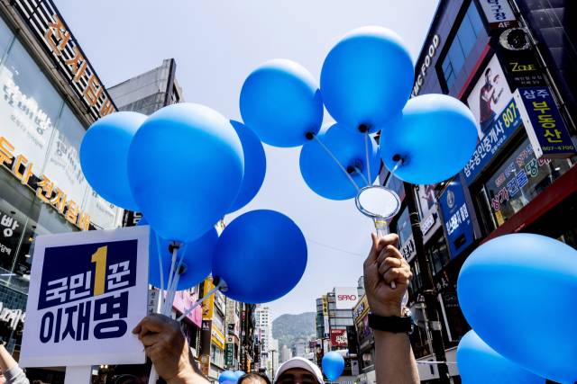 이재명 더불어민주당 대선 후보가 14일 부산 부산진구 서면거리에서 유권자들에게 지지를 호소하고 있는 가운데 지지자들이 파란풍선과 거울을 들고 있다. 부산=오승현 기자 2025.05.14