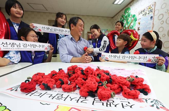스승의날을 하루 앞둔 14일 경기도 수원시 권선구 중촌초등학교에서 수원애(愛)통통봉사단원들이 양말목 카네이션을 만들어 전달하고 있다. 연합뉴스
