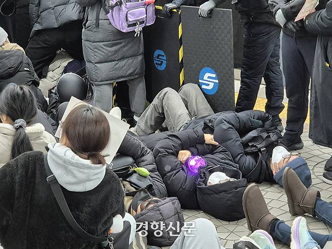 지난해 12월 14일 시민들이 서울 지하철 3호선 안국역 승강장에서 응원봉을 안은 채 전장연의 다이인(die in) 행동에 동참하고 있다. 이예슬 기자