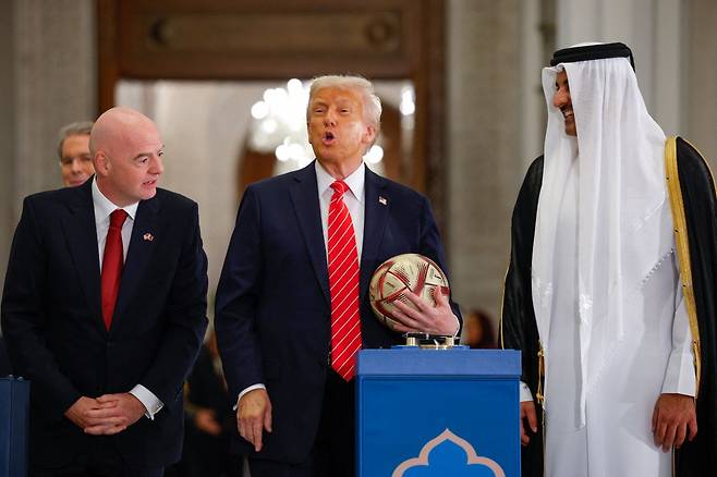 도널드 트럼프 미국 대통령이 14일(현지시간) 카타르 수도 도하에서 타밈 빈 하마드 알사니 카타르 국왕, 지아니 인판티노 국제축구연맹(FIFA) 회장과 함께 한 행사에서 축구공을 들고 있다. 연합뉴스