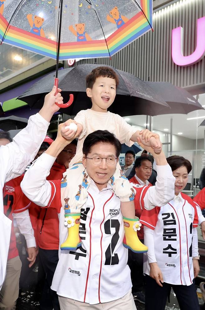 [김문수 국민의힘 대선후보가 16일 대전 중구 으능정이 거리에서 아이를 목마 태우고 도보유세를 하고 있다.뉴시스