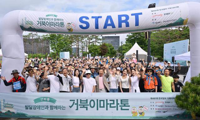 제491회 한국일보 거북이마라톤 '굿피플 발달장애인 인식개선을 위한 거북이마라톤'이 열리는 17일 오전 서울 중구 남산 백범광장에서 참가자 및 내빈이 출발 전 기념사진 촬영을 하고 있다. 왼쪽 일곱번째부터 구영모 굿피플 상임이사, 손용석 한국일보 상무. 최주연 기자