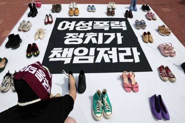 ▲ 4월 27일 서울 홍대입구역 인근에서 젠더폭력 해결 페미니스트 연대 관계자가 기자회견 시작에 앞서 여성 폭력의 상징인 신발을 놓고 있다. ⓒ연합뉴스