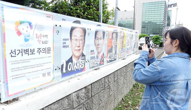 한 시민이 15일 오후 제주시 이도2동 통계교육원 제주수련원 정문 울타리에 부착된 제21대 대통령 선거 후보자 선거벽보를 살피고 있다. 2025.5.15/뉴스1 ⓒ News1 오미란 기자