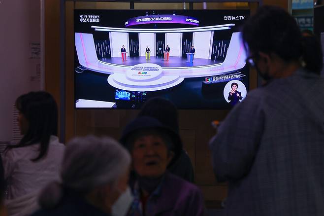 18일 서울역 대합실에서 시민들이 제21대 대선 1차 후보자 토론회 중계방송을 지켜보고 있다. 연합뉴스
