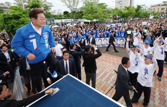 이재명 더불어민주당 대통령 후보가 16일 오후 전북 군산시 구시청광장에서 유세를 펼치기 위해 무대로 오르고 있다.뉴스1