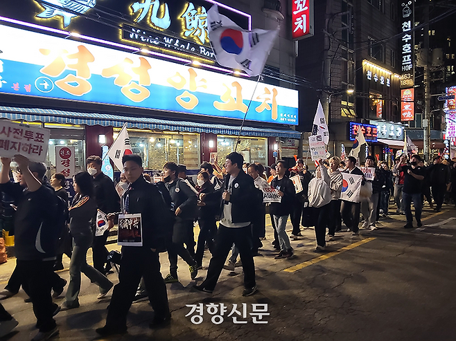 윤석열 전 대통령 지지자들로 구성된 ‘자유대학’이 주최한 ‘사전투표 폐지·부정선거 검증 촉구’ 집회 참가자들이 지난 4월 17일 중국인 가게가 밀집한 서울 광진구 양꼬치거리 일대에서 구호를 외치며 행진하고 있다. 김태욱 기자