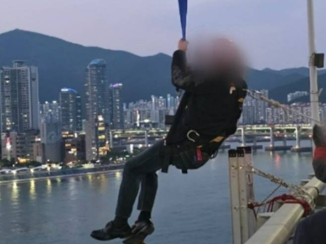 11일 부산 광안대교에서 농성을 벌인 형제복지원 피해 생존자 최승우씨가 8시간 만에 구조되고 있다. 부산경찰청 제공