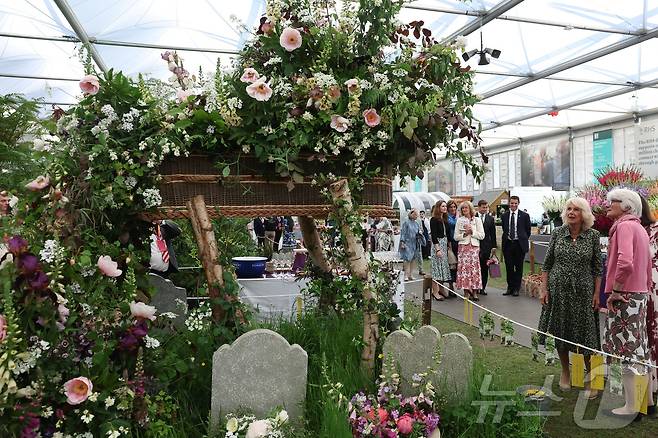 19일(현지시간) 영국 런던에서 열린 RHS 첼시 플라워쇼 프리뷰 행사에서 참석자들이 꽃으로 장식된 관을 바라보고 있다. ⓒ 로이터=뉴스1
