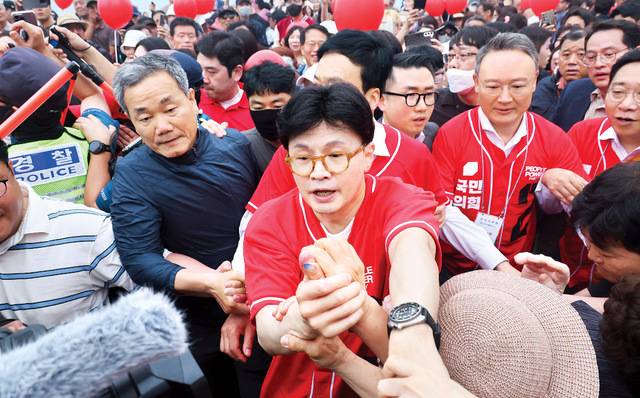 대선 첫 현장 지원유세에 나선 한동훈 전 국민의힘 대표가 20일 부산 수영구 광안리해수욕장 일대에서 시민들과 인사하고 있다. 한 전 대표는 김문수 후보 이름이 적히지 않은 선거운동복을 입었다. 연합뉴스