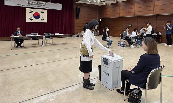 제21대 대통령 선거 재외투표 첫날인 20일 주일본 한국대사관 영사부가 있는 도쿄 미나토구 민단 중앙회관에 마련된 재외투표소에서 유권자가 투표함에 투표용지를 넣고 있다. 도쿄=연합뉴스