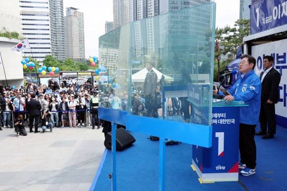 이재명 더불어민주당 대선 후보가 19일 서울 용산역 광장에서 열린 집중유세에서 연설하고 있는 가운데 이 후보 주변으로 ‘방탄 유리막’이 설치돼 있다. 연합뉴스