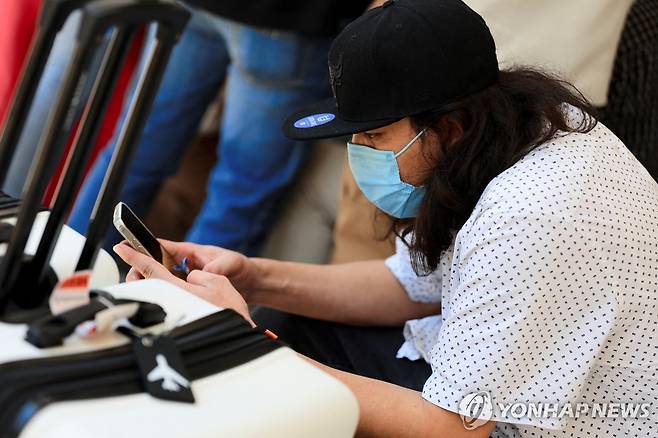 미국에서 자진출국해 온두라스로 돌아온 불법체류자 (산페드로술라 로이터=연합뉴스) 19일(현지시간) 미국에서 자진 추방 형식으로 송환된 불법체류자가 온두라스 산페드로술라 지역에서 휴대전화를 들여다보고 있다. 2025.5.19