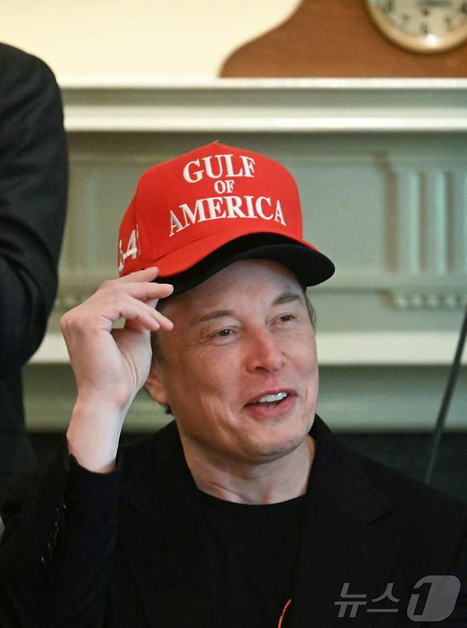 일론 머스크 미국 정부효율부(DOGE) 수장이 30일(현지시간) 워싱턴 백악관에서 도널드 트럼프 대통령 주재의 각료회의서 검은색 모자 위에 '미국 만'이라고 쓰인 빨간색 모자를 겹쳐 쓰고 참석하고 있다. ⓒ AFP=뉴스1 ⓒ News1 우동명 기자