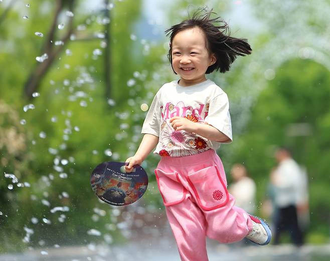A child runs through the jets of water at a fountain in Gwanghwamun Plaza, Seoul, on Tuesday. (Yonhap)