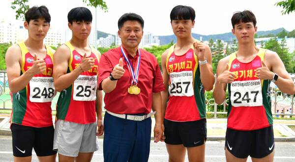 21일 밀양종합운동장에서 열린 제54회 전국종별육상대회 남고 400m 계주서 시즌 3관왕을 차지한 경기체고 선수들이 김호철 교장(가운데)과 기념촬영을 하고 있다. 경기체고 제공