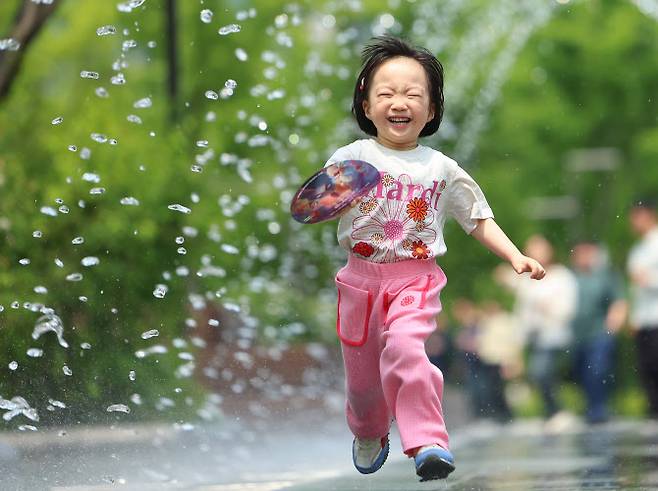 지난 20일 서울 광화문광장을 찾은 어린이가 환하게 웃으며 분수터널을 지나고 있다. (사진=연합뉴스)