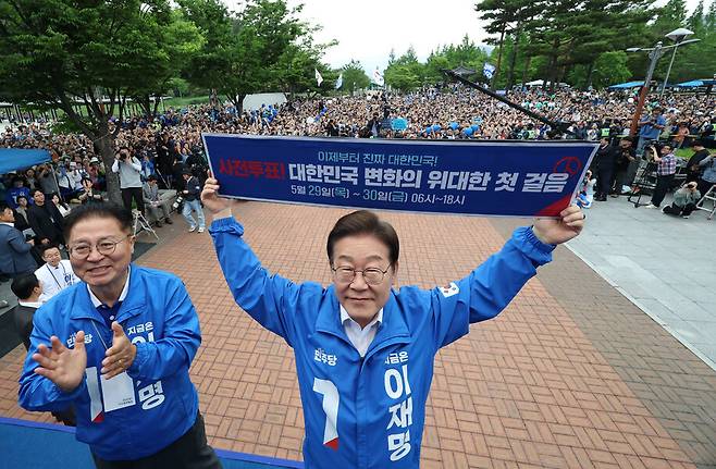 이재명 더불어민주당 대통령 후보가 22일 오후 경남 양산시 양산워터파크공원에서 열린 집중유세에서 사전투표를 독려하는 손팻말을 들어 보이고 있다. 공동취재사진