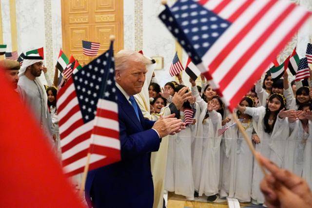 미국 신용등급이 하락하기 전날인 15일 도널드 트럼프 미국 대통령이 셰이크 무함마드 빈 자이드 알나하얀 아랍에미리트(UAE) 대통령과 함께 아부다비의 카사르 알와탄 대통령궁에 도착해 어린이들의 환영을 받고 있다. 아부다비=AP/뉴시스