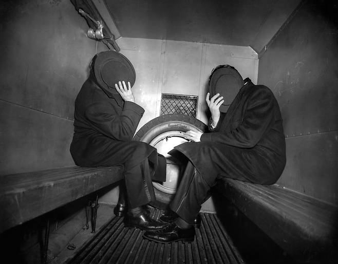 찰스 소도코프와 아서 웨버는 경찰 밴이 그들을 데려가자 모자로 얼굴을 숨겼다. 이들은 뉴욕의 한 바에서 술에 취해 경찰관을 폭행한 혐의로 체포되었다. 1942년, 위지 촬영