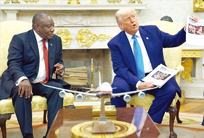 도널드 트럼프 미국 대통령이 21일(현지시간) 백악관에서 시릴 라마포사 남아프리카공화국 대통령과 회담 도중 남아공의 ‘백인 농부 집단 살해’ 의혹을 제기하며 관련 기사 뭉치를 들어 보이고 있다. /AP연합뉴스