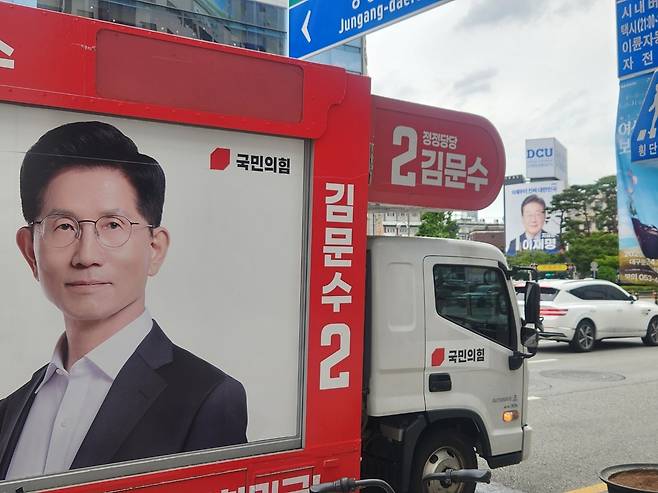 지난 21일 오후 대구 중구 동성로 일대. 김문수 국민의힘 대선 후보의 유세차 뒤로 이재명 더불어민주당 대선 후보의 대형 현수막이 걸려있다. 이영기 기자.