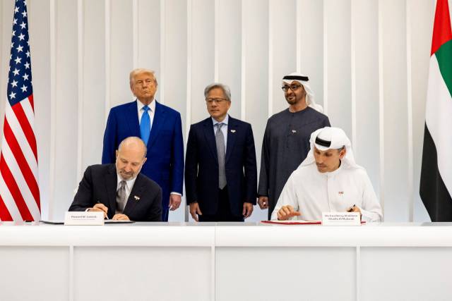 15일(현지 시간) 아랍에미리트(UAE) 아부다비에서 도널드 트럼프(뒷줄 왼쪽) 미국 대통령과 젠슨 황 엔비디아 최고경영자(CEO)가 지켜보는 가운데 하워드 러트닉 미 상무장관(앞줄 왼쪽)과 칼둔 알 무바라크 무바달라 CEO가 ‘미·UAE 인공지능(AI) 파트너십 협정’을 맺고 있다. AFP연합뉴스