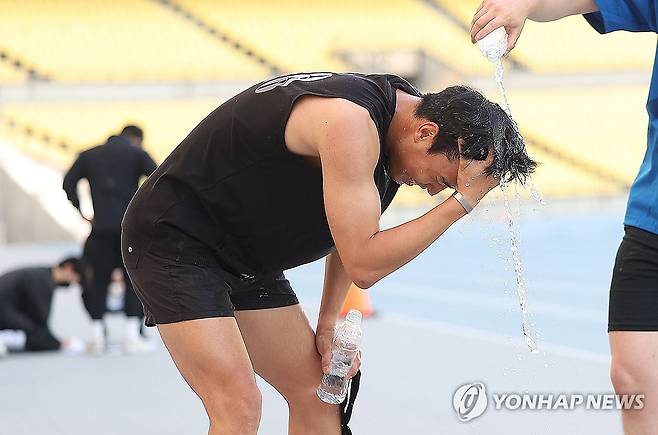 물로 식혀보는 5월의 더위 (대구=연합뉴스) 윤관식 기자 = 대구 낮 최고기온이 33.4도까지 오른 20일 대구스타디움에서 열린 대구시 재난안전기동대 채용 체력 검정을 마친 한 응시자가 시원한 물로 세수하고 있다. 2025.5.20 psik@yna.co.kr