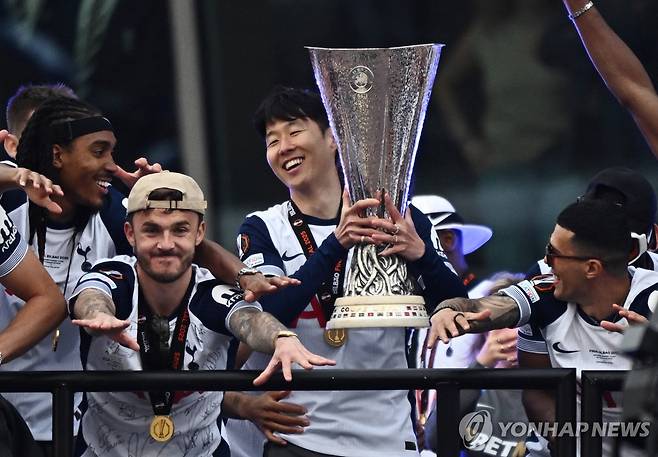퍼레이드 중 트로피 들어올리는 손흥민 (런던 로이터=연합뉴스) 23일(현지시간) 영국 런던 토트넘 홋스퍼 스타디움 앞에서 열린 유럽축구연맹(UEFA) 유로파리그 우승 기념 퍼레이드 행사에서 손흥민(가운데)이 트로피를 들어 올리고 있다.