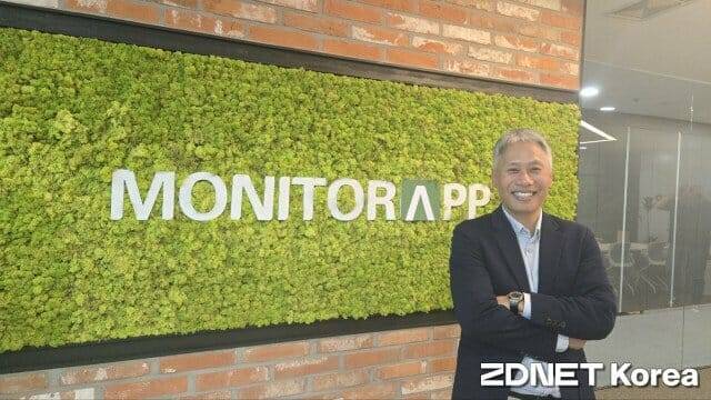 이광후 모니터랩 대표가 회사 CI를 배경으로 미소를 짓고 있다. 연대에서 사학을 전공한 그는 2005년 2월 모니터랩을 설립했다. (사진=방은주 기자)