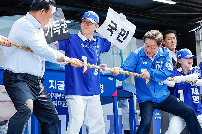 이재명 더불어민주당 대통령 후보가 캐스팅보트인 충청권 공략에 나선 25일 오후 충남 당진전통시장을 찾아 기득권과 국민의 줄다리기 중 국민이 이긴다는 의미의 퍼포먼스를 하고 있다./뉴스1