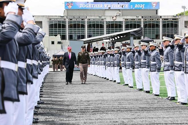도널드 트럼프 미국 대통령이 24일 뉴욕 웨스트포인트의 미치 스타디움에서 열린 미 육군사관학교 졸업생들에게 연설한 후 스티븐 W. 길랜드 중장과 함께 생도들의 사열을 받고 있다. AFP 연합뉴스