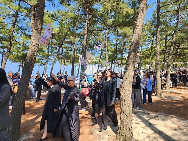 배우 박정자의 지인들이 25일 오후 강릉시 사천면 산대월리 순포해변에서 촬영한 영화 ‘청명과 곡우 사이’에서 만장을 들고 박정자를 따르고 있다.