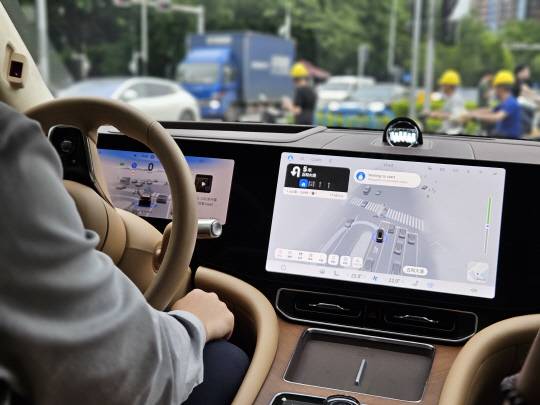 24일 중국 선전 시내의 도로에서 화웨이의 자율주행 시스템이 탑재된 차량이 운전자가 두 손을 무릎에 둔 상태에서 스스로 유턴하고 있다. 김나인 기자