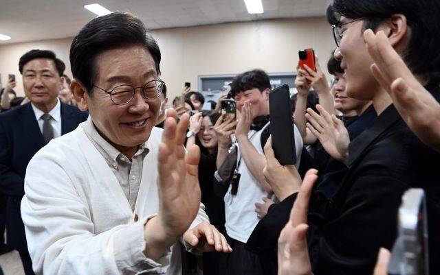 이재명(왼쪽) 더불어민주당 대통령 후보가 26일 오전 경기 수원시 영통구 월드컵로 아주대학교에서 열린 ‘아주대와 함께하는 대학생 간담회’를 마친 뒤 학교를 떠나며 학생들과 하이파이브를 하며 인사하고 있다. 공동취재사진