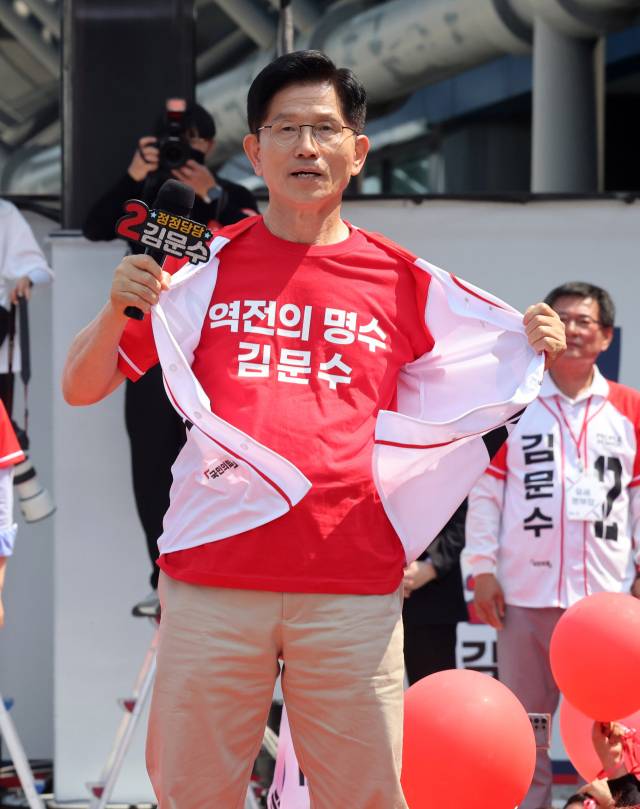 김문수 국민의힘 대선후보가 25일 충남 보령시 대천역 광장앞 선거유세에서 "나는 방탄조끼를 입지 않았다" 며 겉옷을 벗고 있다. 보령=성형주 기자 2025.05.25