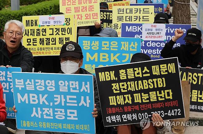 구호 외치는 홈플러스 전단채 피해자들 (서울=연합뉴스) 서명곤 기자 = 17일 서울 종로구 MBK파트너스 본사 앞에서 홈플러스 물품구매 전단채 피해자 비상대책위원회가 연 집회에서 참가자들이 김병주 MBK 회장과 김광일 홈플러스 공동대표의 사채출연을 촉구하는 구호를 외치고 있다. 2025.4.17 seephoto@yna.co.kr