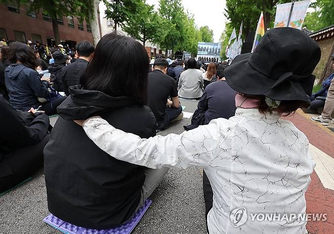 추모 눈물 (서울=연합뉴스) 서명곤 기자 = 24일 서울 경복궁 영추문 앞에서 열린 전국교직원노동조합 창립 36주년 전국교사결의대회에서 한 참가자가 최근 제주도의 한 중학교에서 교사가 사망한 사건과 관련한 발언을 듣다 눈물을 흘리자 동료 교사가 어깨를 감싸주고 있다. 2025.5.24 seephoto@yna.co.kr