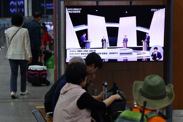 제21대 대통령선거 후보 정치분야 TV토론회가 열린 27일 서울역 대합실에서 시민들이 토론회 중계방송을 지켜보고 있다.연합