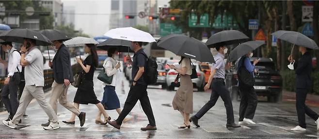 기상 예보 기술에도 인공지능 도입이 한창이다. 이런 가운데 나비 효과로 인한 기상 예보의 한계선으로 알려진 ‘2주 한계’를 넘어 30일까지도 기상 예보를 할 수 있을 가능성이 인공지능 연구진에 의해 최근 제기됐다. 사진은 비 오는 날에 서울 종로구 광화문네거리에서 우산을 쓴 채 오가는 시민들의 모습. 연합뉴스