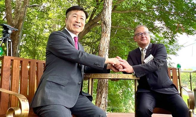 26일 서울 서초구 양재천 ‘바츨라프 하벨 벤치’ 개장식에서 전성수 서초구청장(왼쪽)과 이반 얀차렉 주한 체코 대사가 두 손을 맞잡고 있다. 원형 테이블과 의자 두 개로 구성된 이 벤치는 개방성과 민주주의를 상징한다. 서초구 제공