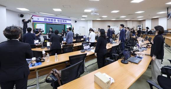 이재명 더불어민주당 대선 후보의 공직선거법 위반 사건을 대법원이 파기환송한 것을 계기로 열린 전국법관대표회의 임시회의가 26일 열렸지만 입장 채택 없이 대선 이후 논의를 이어 가기로 했다. 이날 법관대표회의에 참석한 법관들이 국기에 대한 경례를 하고 있는 모습. 뉴스1