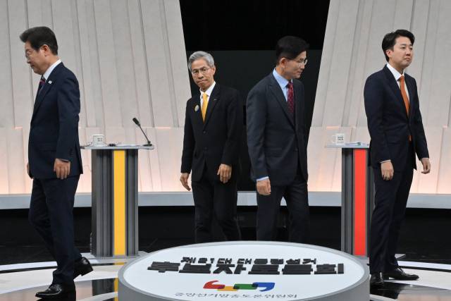 이재명(왼쪽부터) 더불어민주당, 권영국 민주노동당, 김문수 국민의힘, 이준석 개혁신당 대선 후보가 27일 서울 마포구 MBC에서 진행된 정치 분야 토론회에 앞서 손을 맞잡고 기념 촬영을 한 뒤 각자 자리로 향하고 있다. 연합뉴스