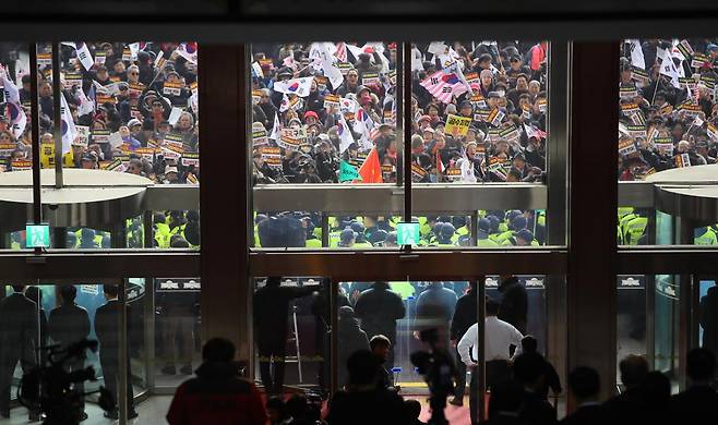 2019년 12월16일 오전 서울 여의도 국회 본청 앞 계단에서 열린 ‘공수처법·선거법 날치기 저지 규탄대회’에 참여한 참가자들이 본청 진입을 시도하며 경찰과 대치하고 있다. ⓒ연합뉴스