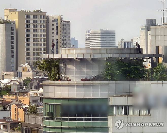 강남역 인근 건물 옥상서 투신 소동 (서울=연합뉴스) 김준태 기자 = 지난 13일 서울 지하철 2호선 강남역 인근 빌딩 옥상에서 한 남성이 투신 소동을 벌여 경찰관과 구조대원들이 구조를 위해 접근하고 있다. 2025.5.27 readiness@yna.co.kr