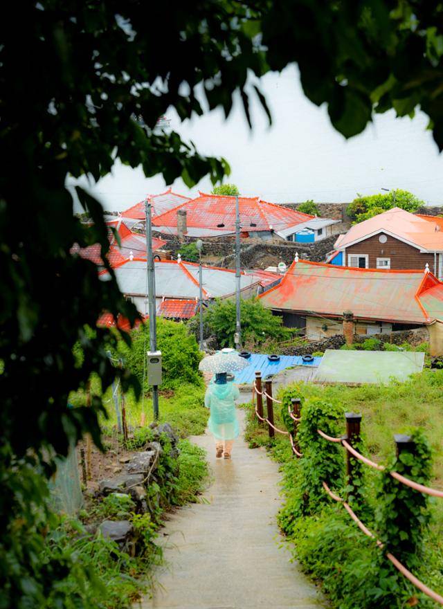 쑥섬의 정원과 숲에서 마을로 이어지는 길 너머로 붉은 지붕 일색인 마을이 보인다.