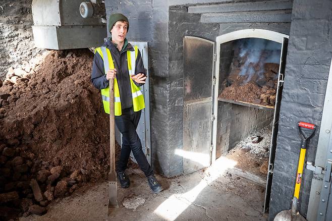 라프로익 증류소의 피트 화덕 앞.잘게 부순 피트가 한쪽에 쌓여 있고, 일부는 화덕에 넣어 불이 붙어 있다. 이 연기가 위층 몰팅 플로어로 올라가 보리에 특유의 향을 입힌다. /김지호 기자