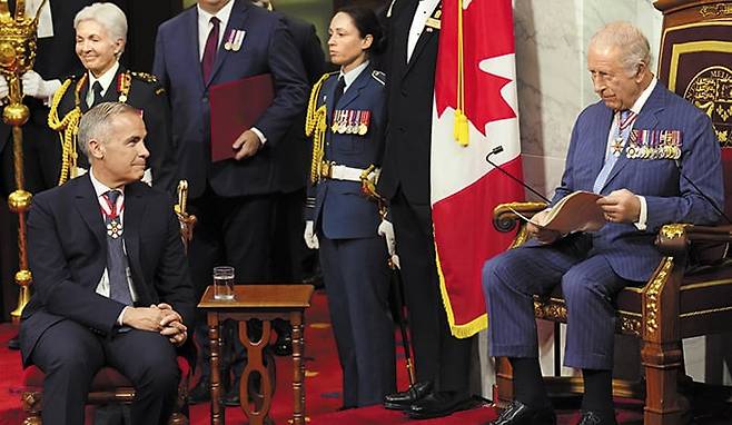 지난 27일 마크 카니(왼쪽) 캐나다 총리가 오타와 국회의사당에서 ‘왕좌의 연설’을 하기 위해 국왕의 좌석에 앉은 찰스 3세(오른쪽)를 바라보고 있다. 캐나다 국왕이기도 한 찰스 3세는 이날 영국 국왕으로서 48년 만에 캐나다를 직접 방문해 ‘왕좌의 연설’을 했다. /AP 연합뉴스